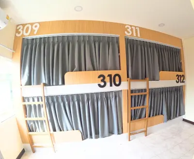 a room with gray curtains in a room with a bed at KPOP Hostel in Karon Beach