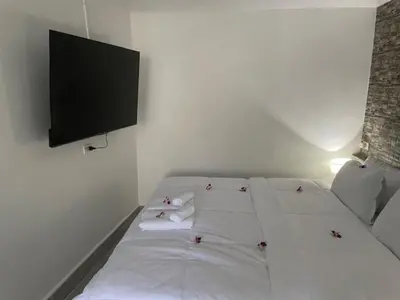 a white bed with towels and a flat screen tv at My Home in Patong Beach