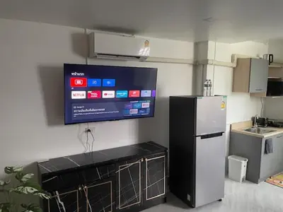 a kitchen with a refrigerator and a tv on the wall at My Home in Patong Beach