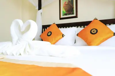 two swans made out of white sheets on a bed at Harmony Patong Hotel in Patong Beach