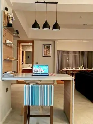 a kitchen with a table with a laptop on it at Waterfront Suites Phuket by Centara NEW in Phuket Town
