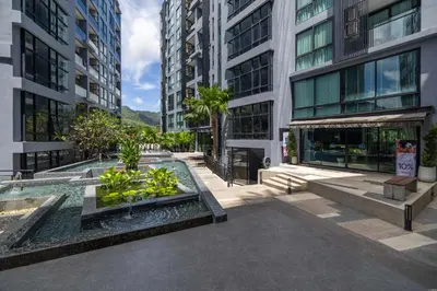 a building with a fountain in the middle of a street at Modern Condo in Boutique Style Resort CGB4 in Phuket Town