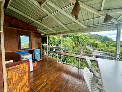 a room with a table and chairs and a balcony at Hilltop view - Phi Phi in Phi Phi Don