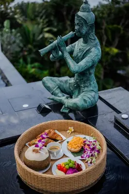 a statue of a man holding a gun next to a tray of food at Villa ZeniMo in Phuket Town