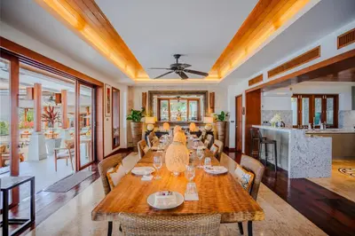 a dining room with a long table and chairs at Villa ZeniMo in Phuket Town