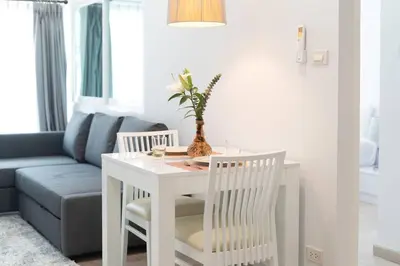 a living room with a white table and a couch at Brand New Patong Apartment 1-Bedroom in Patong Beach