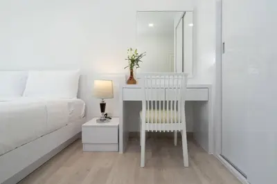 a bedroom with a bed and a desk with a chair at Brand New Patong Apartment 1-Bedroom in Patong Beach