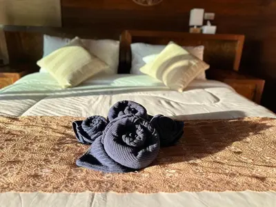 a blue towel on top of a bed at บ้านสวนปิยนันท์ (Baansuan Piyanan) in Ko Yao Noi