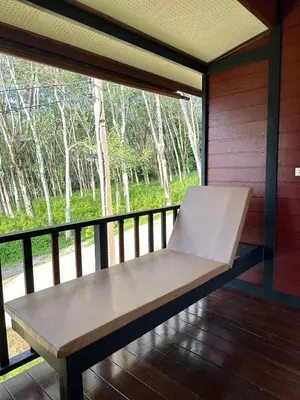 a bench sitting on a porch with a window at บ้านสวนปิยนันท์ (Baansuan Piyanan) in Ko Yao Noi