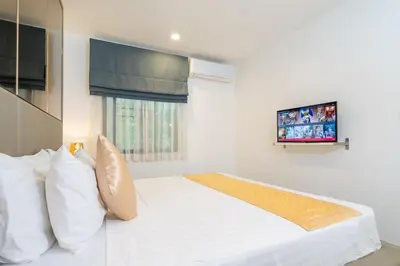 a bedroom with a white bed and a tv at F11 Title 50м2 Люкс Бассейн Рубль ВАТСАП669З582I976 in Nai Yang Beach