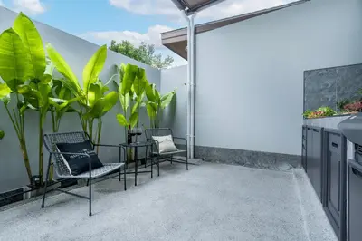 a patio with two chairs and a table and plants at Two Flamingo Villa 1 in Ban Pak Lak