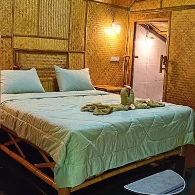 a bed with a stuffed animal sitting on top of it at Ratanaporn Green in Phuket Town