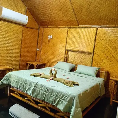 a person laying on a bed in a room at Ratanaporn Green in Phuket Town