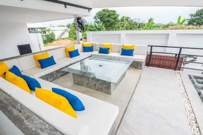 a living room with a couch and a glass table at Mango Hill Residence in Rawai Beach