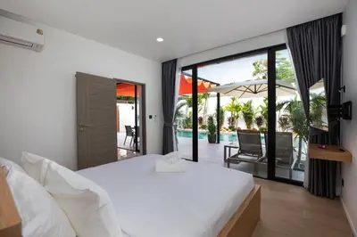 a bedroom with a bed and a view of a pool at Mango Hill Residence in Rawai Beach
