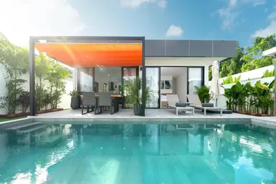 a villa with a swimming pool in front of a house at Mango Hill Residence in Rawai Beach
