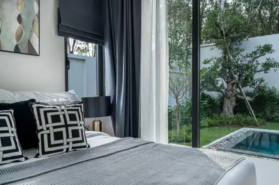a bedroom with a bed and a window with a swimming pool at Space villa Botanica Modern Loft in Ban Pak Lak