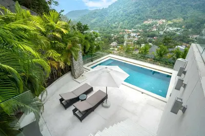 a swimming pool with a chair and an umbrella at Serenity and Modern Art - Open Hill View 3BR Natural Park Villa 1 in Kamala Beach
