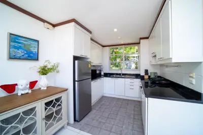 a kitchen with white cabinets and a black refrigerator at Scenic Seaview Villa Sea Dream for 9, Tennis Court, 5min walk to Kata Noi Beach in Kata Beach