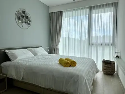 a bedroom with a bed with two yellow towels on it at 2 bedroom Condo at Cassia Laguna in Bang Tao Beach