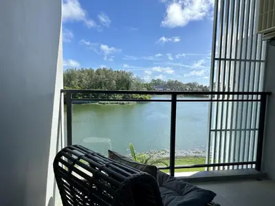 a balcony with a chair and a view of a lake at 2 bedroom Condo at Cassia Laguna in Bang Tao Beach