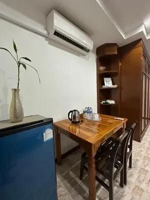 a kitchen with a wooden table and a refrigerator at BT hotel Kata Beach in Kata Beach