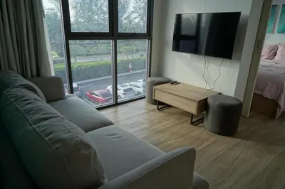 a living room with a couch and a flat screen tv at Modern 2-bedroom Apartments with washer in Skypark Laguna Bang Tao in Phuket Town