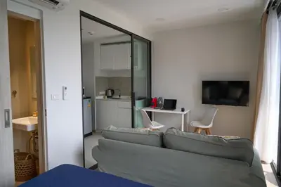 a living room with a couch and a kitchen at Cozy 1-bedroom Apartments in Laguna Skypark Bang Tao in Phuket Town