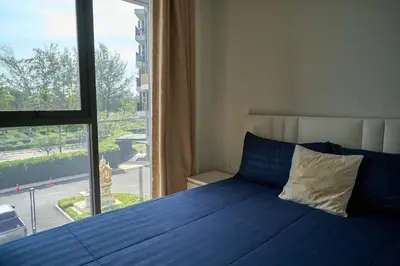 a bedroom with a blue bed and a large window at Cozy 1-bedroom Apartments in Laguna Skypark Bang Tao in Phuket Town