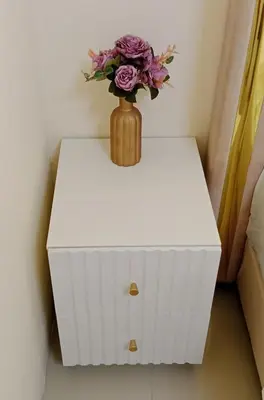 a vase with flowers on top of a white table at STP apartment 2rd floor in Patong Beach