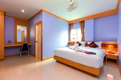 a bedroom with a bed with a stuffed animal on it at Phusita Hotel - SHA Certified in Patong Beach