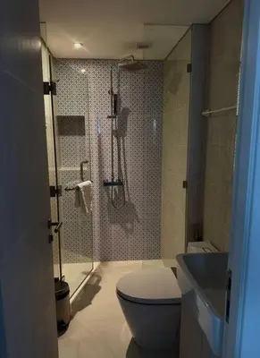 a bathroom with a shower and a toilet and a sink at Cassia Residences in Phuket Town