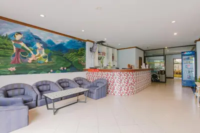 a waiting room with blue chairs and a painting on the wall at Sunstar Palace Patong in Patong Beach
