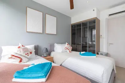 two beds sitting next to each other in a bedroom at Cassia 2 BR Sea View apt by NLA in Phuket Town