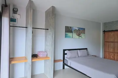 a bedroom with a bed and a wooden shelf at Aonangstudio in Krabi town