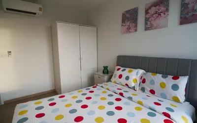 a bedroom with a bed with polka dot pillows at Modern 2-bedroom Apartments Garden view in Skypark Laguna Bang Tao in Bang Tao Beach