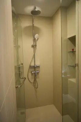 a bathroom with a shower with a glass door at Modern 2-bedroom Apartments Garden view in Skypark Laguna Bang Tao in Bang Tao Beach