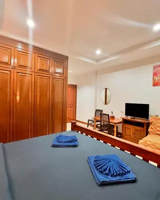 a bedroom with a bed with blue napkins on it at BT hotel Kata Beach in Kata Beach