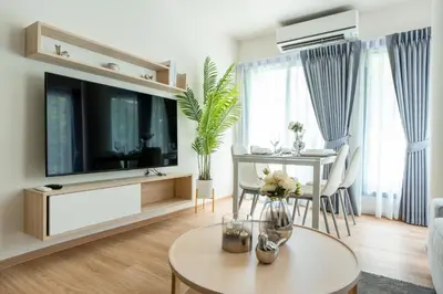 a living room with a large television and a table at Phyll Phuket 2 BR apartment near Central Festival by NLA in Phuket Town