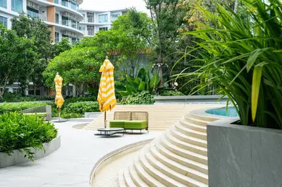 a courtyard with a bench and umbrellas at Phyll Phuket 2 BR apartment near Central Festival by NLA in Phuket Town