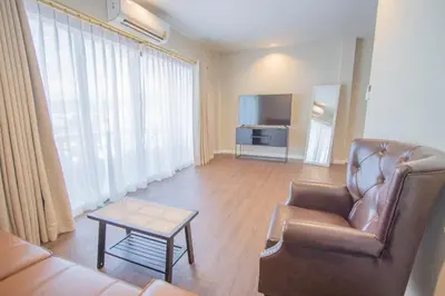 a living room with a couch and a tv at The Va Phuket Patong in Patong Beach