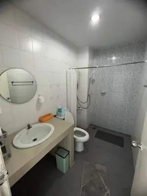 a bathroom with a sink and a toilet and a mirror at Petunya Room 3 in Ban Huai Luk (1)