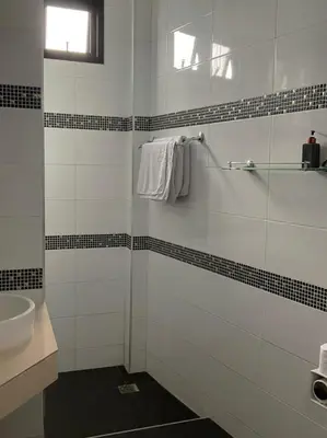 a white bathroom with a sink and a shower at Sj House Hotel Aonang in Ban Khlong Haeng