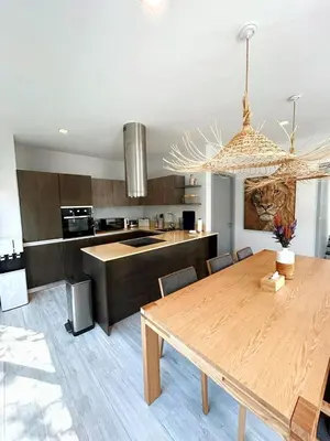 a kitchen with a wooden table and a dining room at A spacious Balinese style villa with a large swimming pool on Rawai an electric motorcycle as a gift! in Ban Saiyuan (1)