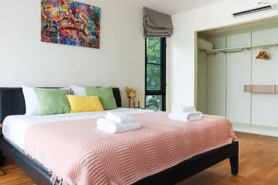 a bedroom with a large bed with towels on it at Friendly Townhouse Laguna Park in Thalang