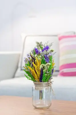 a glass jar filled with flowers on a table at Reach Patong beach in one minute in Patong Beach