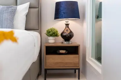 a lamp on a night stand next to a bed at Reach Patong beach in one minute in Patong Beach