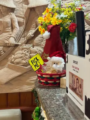 a santa claus toy in a basket on a table with flowers at Priew Wan Guesthouse in Patong Beach