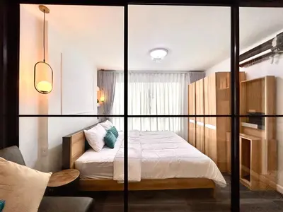 a bedroom with a bed and a glass wall at Vibe Old Town 452 in Phuket Town