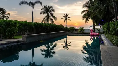 a pool with a pink flamingo and palm trees at The Natai Villas - By AP Natai in Phang-nga